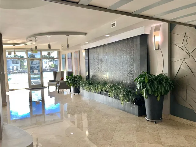 a lobby with furniture and potted plants