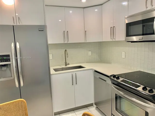 a kitchen with a sink stainless steel appliances and cabinets