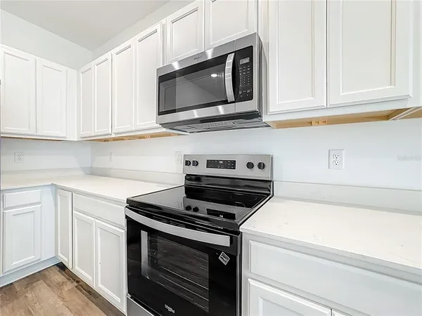 a kitchen with stainless steel appliances granite countertop white cabinets a sink and dishwasher