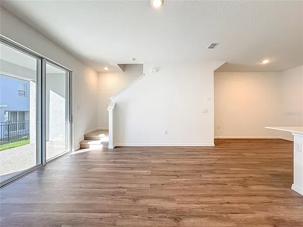 a view of an empty room with wooden floor