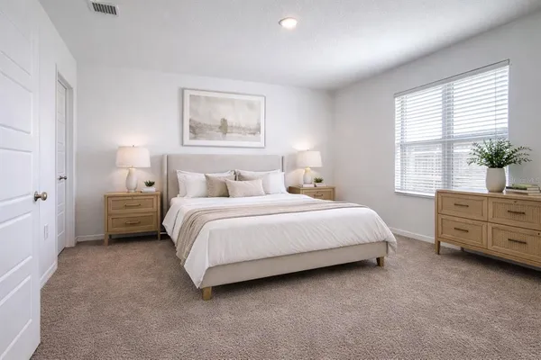 a bedroom with a bed dresser and window