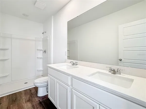 a bathroom with a sink toilet vanity and shower