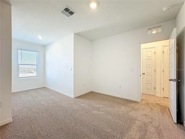 an empty room with windows and closet