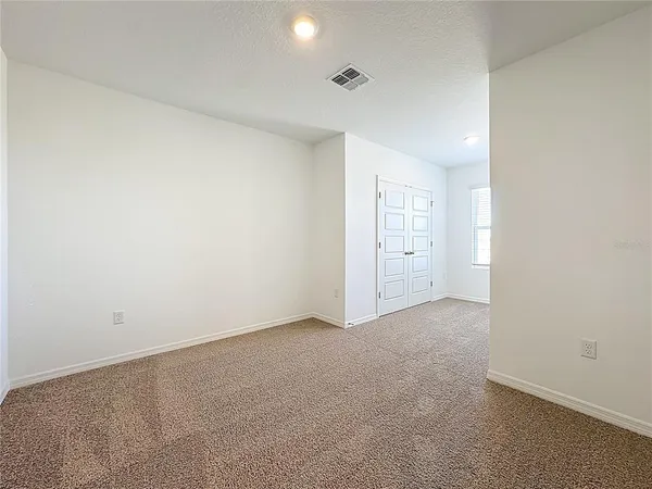 an empty room with white wall and closet