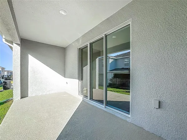 a view of a house with brick walls and a yard with plants