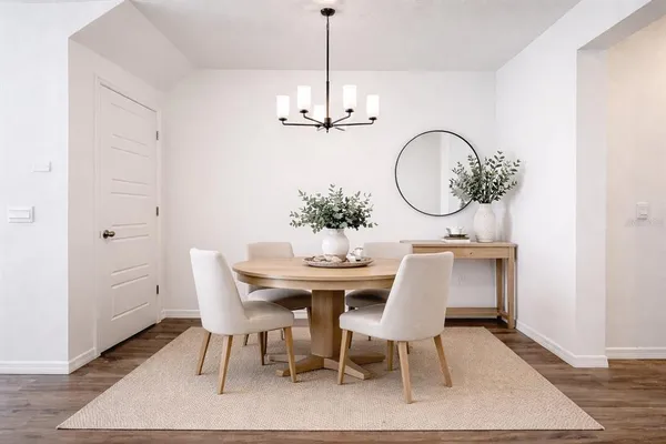 a dining room with furniture a rug and a chandelier