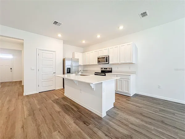 a kitchen with white cabinets and white appliances