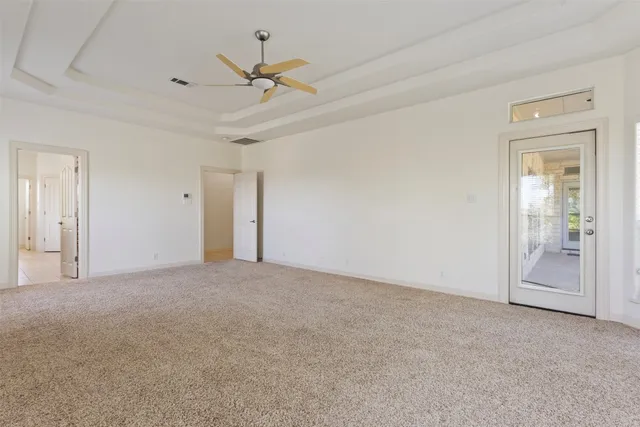 an empty room with windows and fireplace