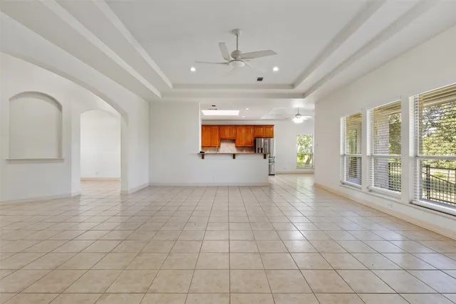 an empty room with windows and ceiling fan