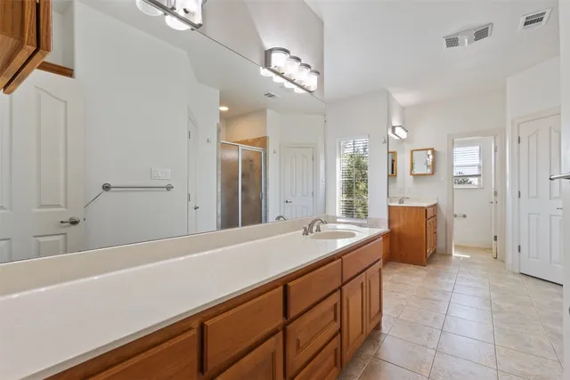a spacious bathroom with sinks a large mirror and a bathtub next to a window