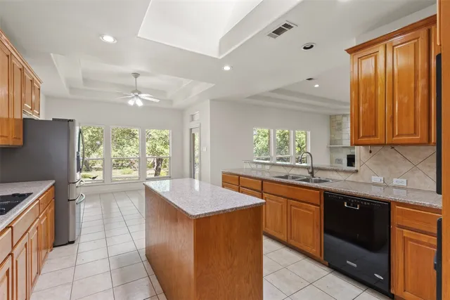 a kitchen with granite countertop stainless steel appliances a refrigerator sink and microwave