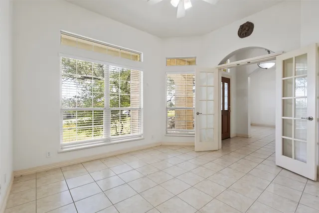 an empty room with windows and fireplace
