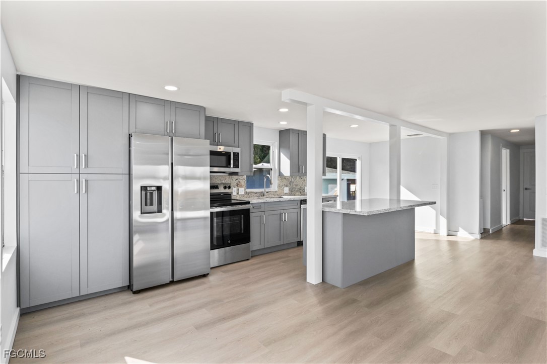 a kitchen with stainless steel appliances a refrigerator and a stove top oven
