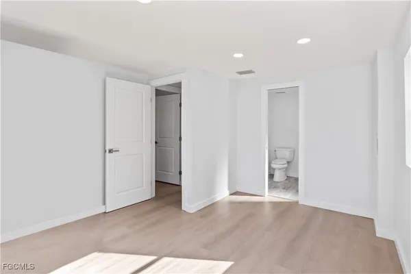 an empty room with closet and wooden floor