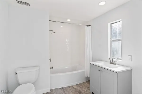 a bathroom with a toilet a sink a mirror and bathtub