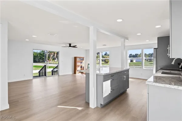 a large kitchen with stainless steel appliances granite countertop a large window and a sink