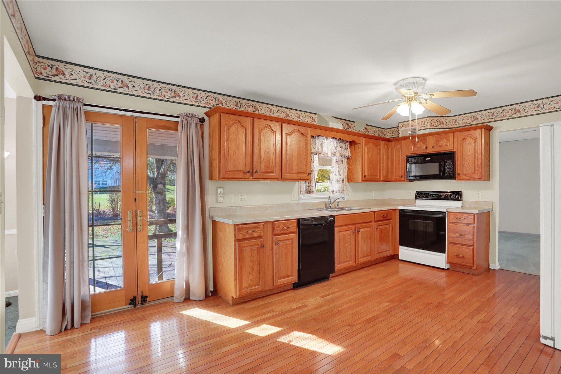 156 Chester Street Carlisle, PA 17013 - Photo 11 of 36 a kitchen with stainless steel appliances granite countertop a refrigerator a sink dishwasher a stove with wooden cabinets and floor