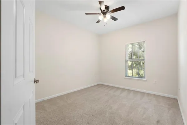 an empty room with a window and a fan