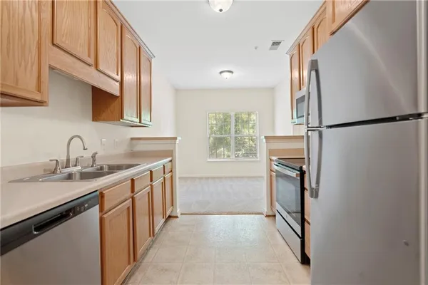 a kitchen with a sink a refrigerator and cabinets