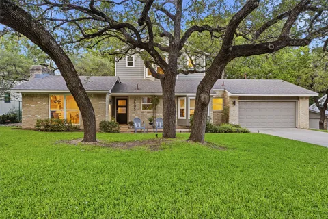 a front view of a house with a garden and yard
