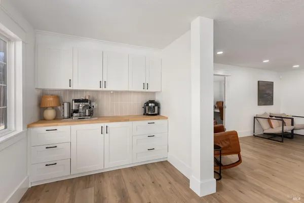 a kitchen with stainless steel appliances granite countertop a stove a sink and white cabinets