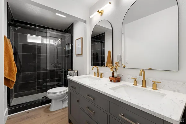 a bathroom with a sink a toilet and shower