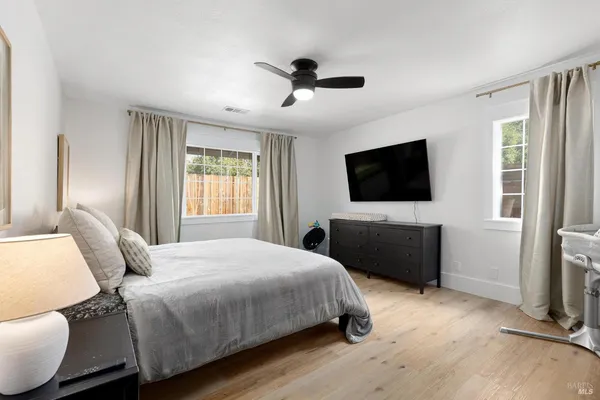 a bedroom with a bed tv and a window