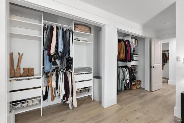 a view of walk in closet with clothes and shoes