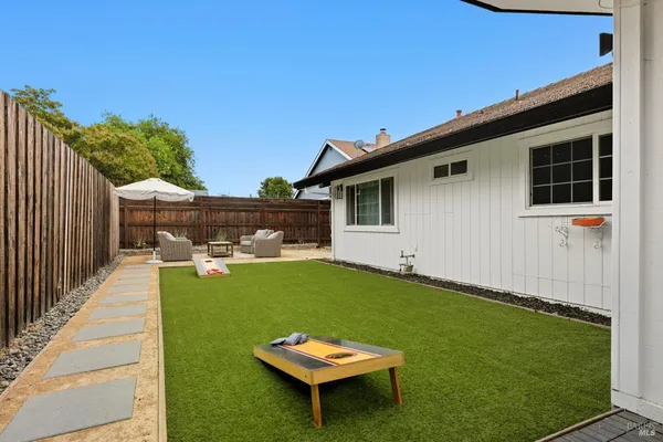 a backyard of a house with table and chairs