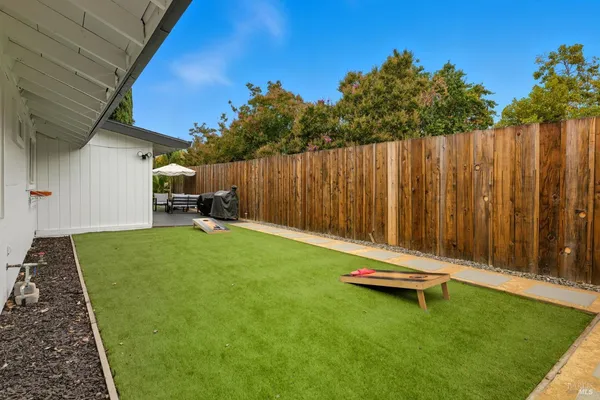 a backyard of a house with table and chairs