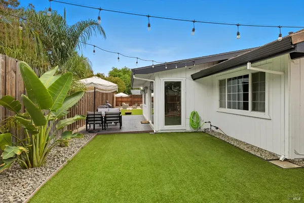 a backyard of a house with table and chairs