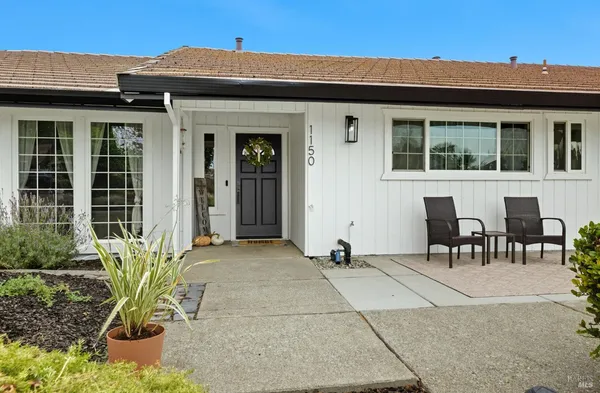 a view of a chair and table in front of house