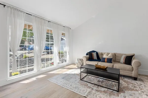 a living room with furniture and a floor to ceiling window
