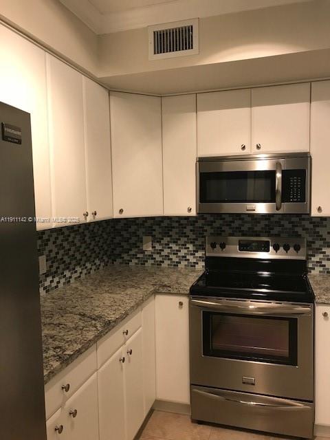 2469 Centergate Drive, Unit 203 Miramar, FL 33025 - Photo 8 of 13 a kitchen with granite countertop white cabinets and stainless steel appliances