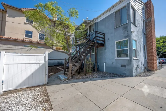 a backyard of a house with large trees and barbeque oven