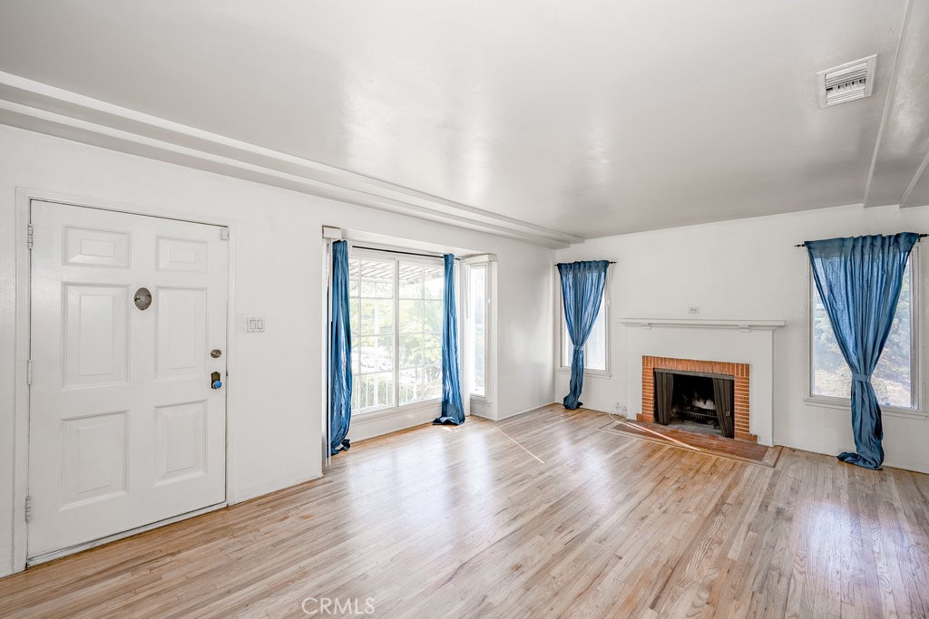 711 North Howard Street Glendale, CA 91206 - Photo 5 of 20 an empty room with wooden floor fireplace and windows