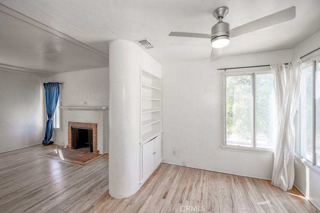 711 North Howard Street Glendale, CA 91206 - Photo 6 of 20 an empty room with wooden floor fireplace and windows