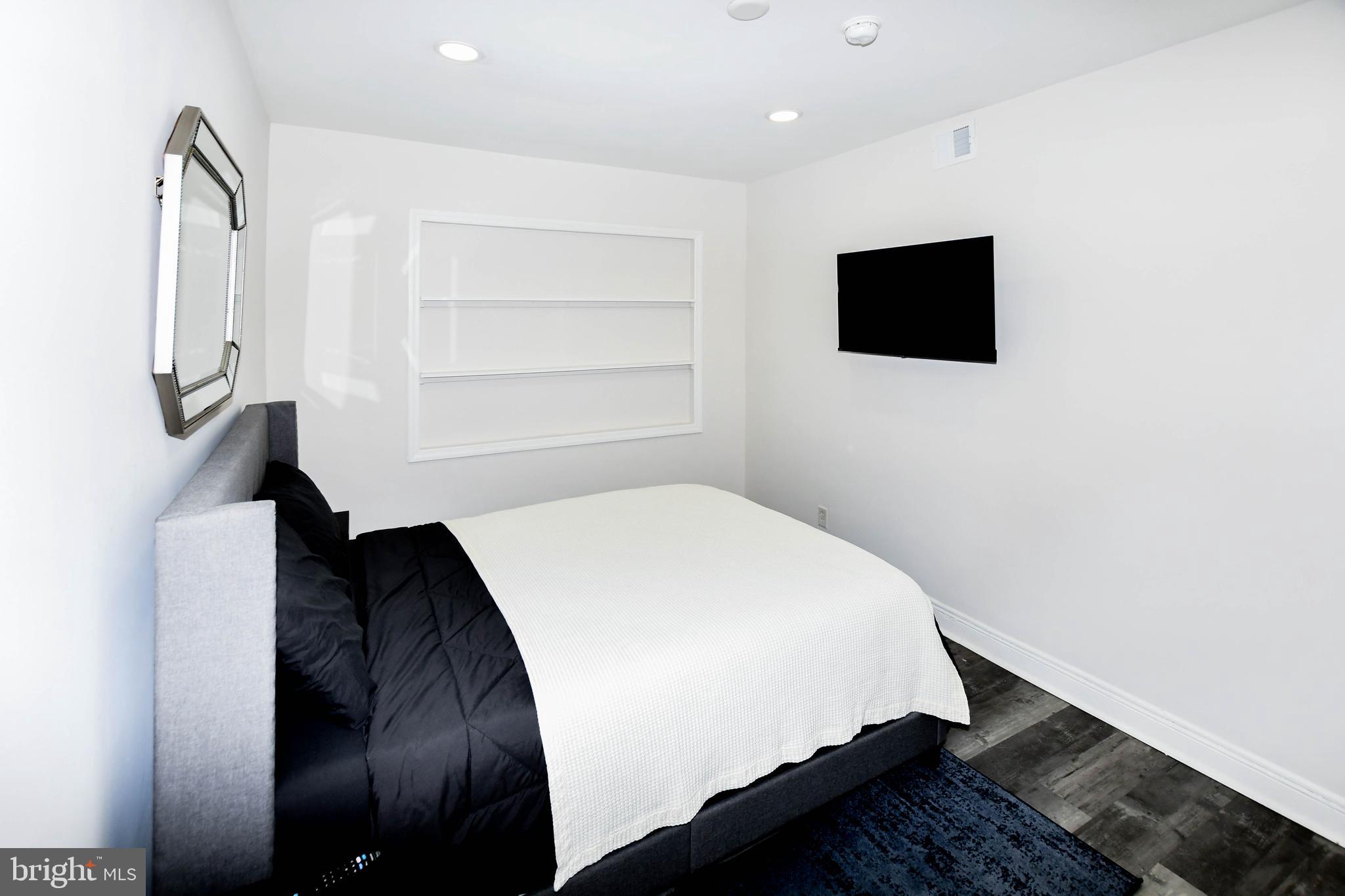 554 Newcomb Street Southeast, Unit 4 Washington, DC 20032 - Photo 19 of 34 a bedroom with a bed and a flat screen tv