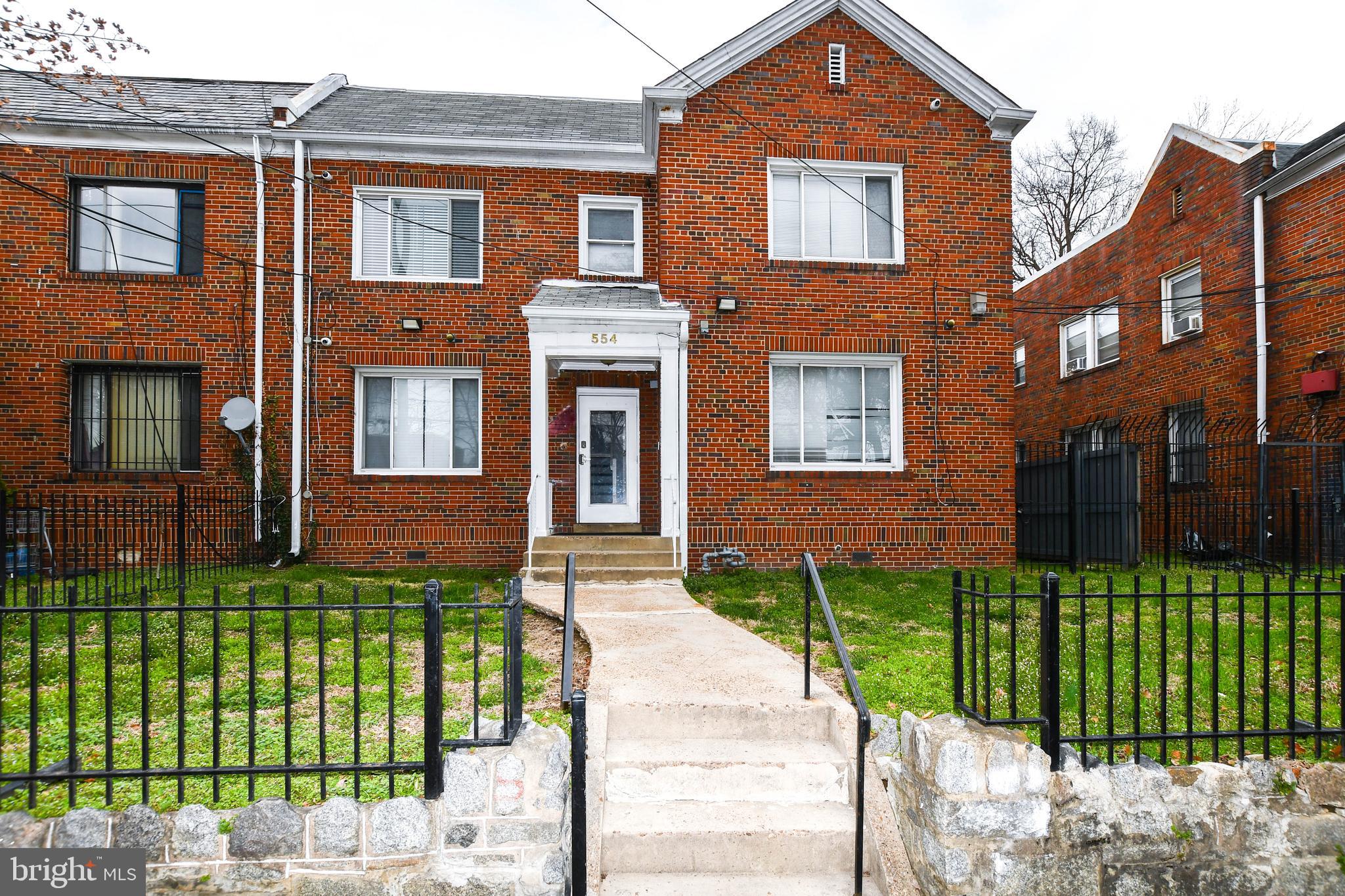 554 Newcomb Street Southeast, Unit 4 Washington, DC 20032 - Photo 2 of 34 a front view of a house with a garden
