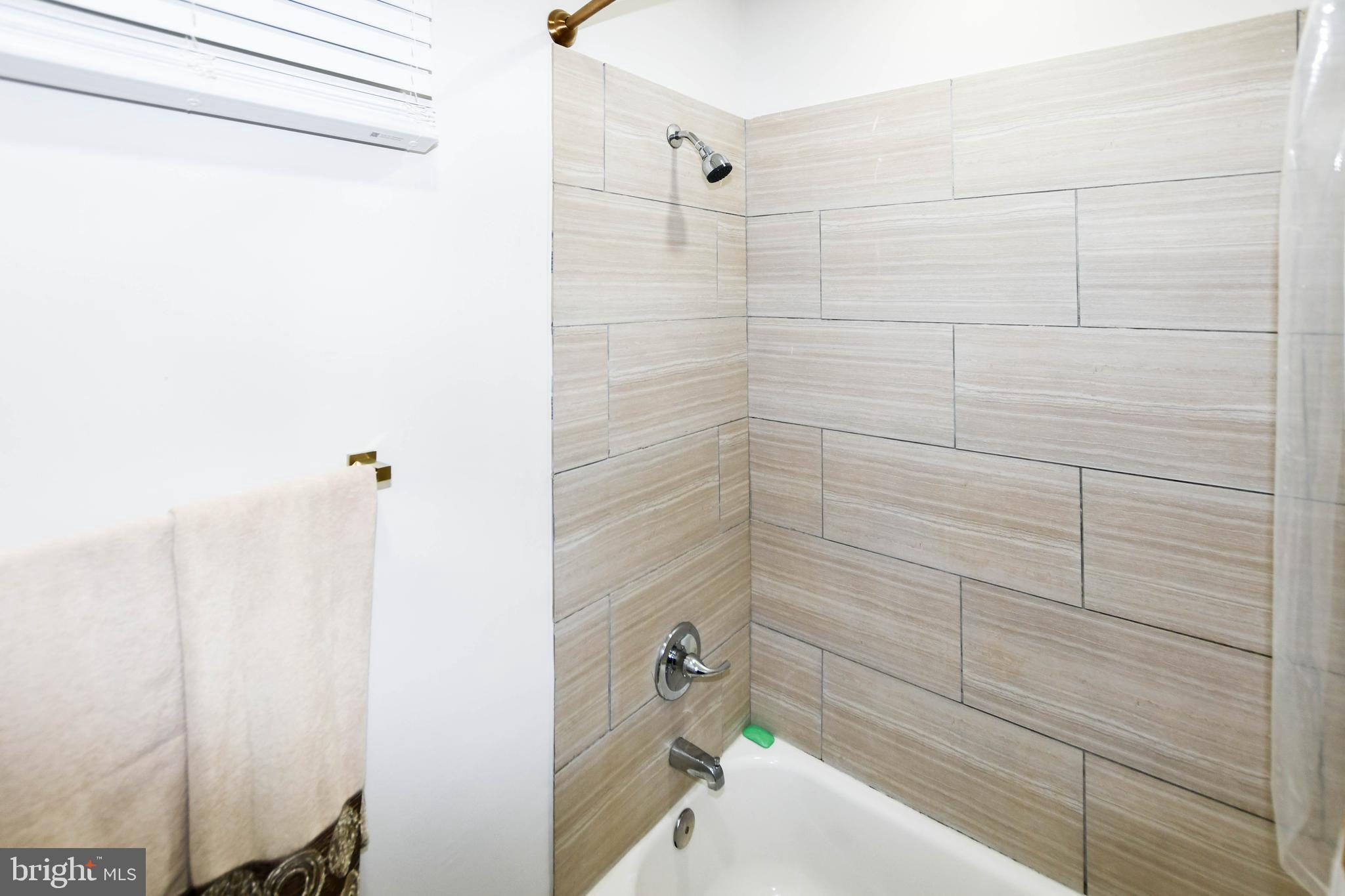 554 Newcomb Street Southeast, Unit 4 Washington, DC 20032 - Photo 23 of 34 a bathroom with a bathtub and shower