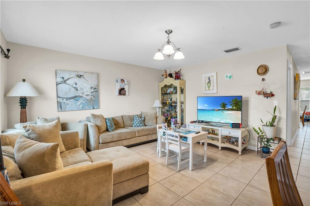2388 55th Terrace Southwest Naples, FL 34116 - Photo 7 of 42 Tiled living room with a chandelier