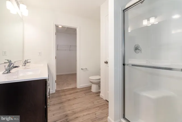 a bathroom with a sink a toilet and shower