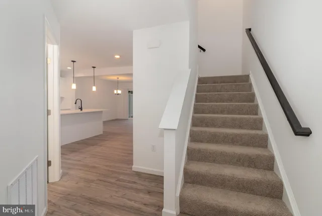 a view of a hallway with wooden floor and staircase