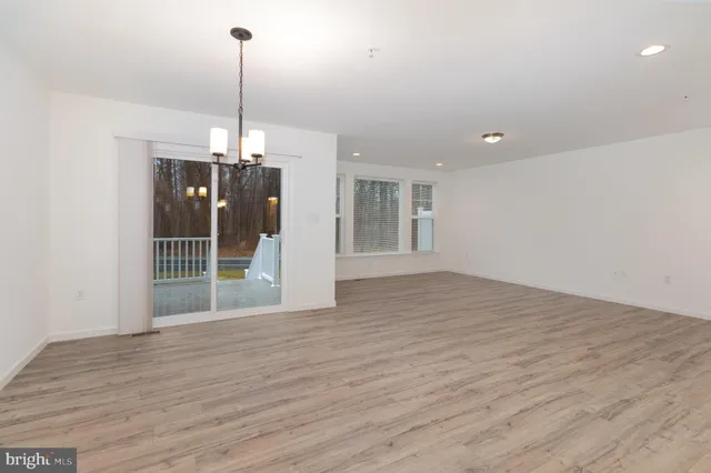 a view of a room with wooden floor kitchen and window