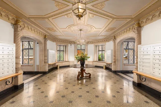 a front view of a building with a garden and plants