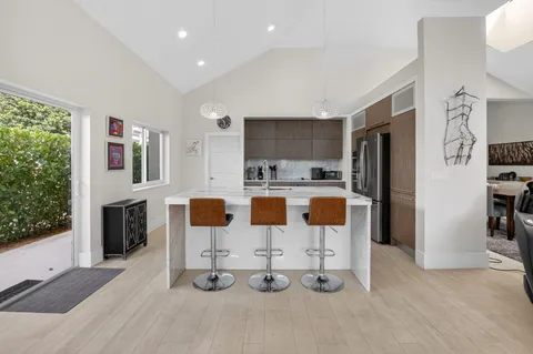 a kitchen with stainless steel appliances kitchen island granite countertop a refrigerator and microwave