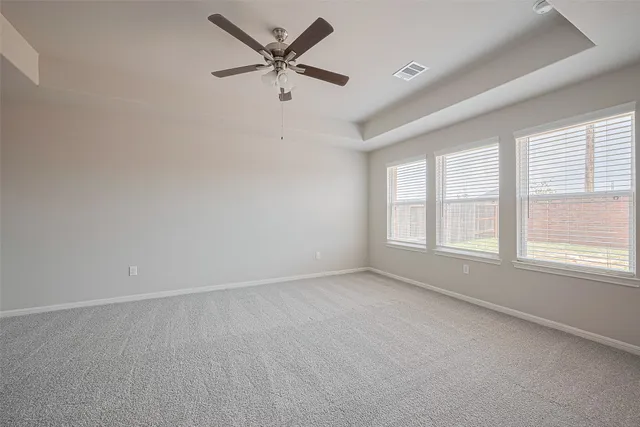 an empty room with a window and a fan