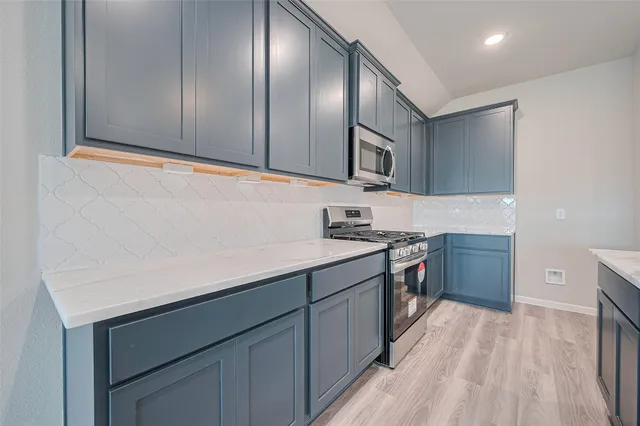 a kitchen with stainless steel appliances granite countertop a sink stove and cabinets