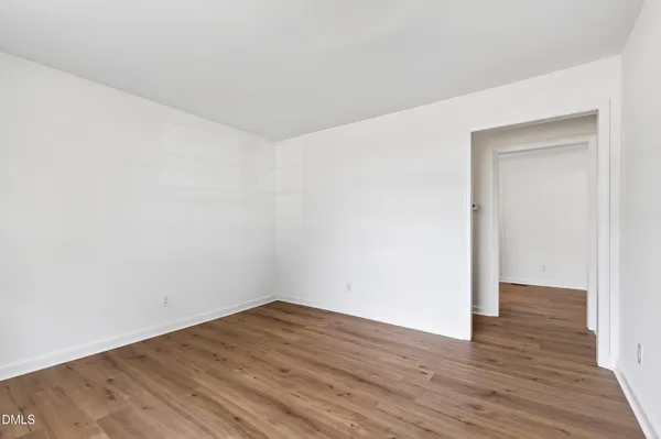 a view of an empty room with wooden floor