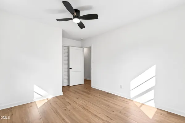 a view of empty room with wooden floor